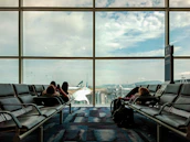 Couple looking at plane tickets with a travel agent nearby.