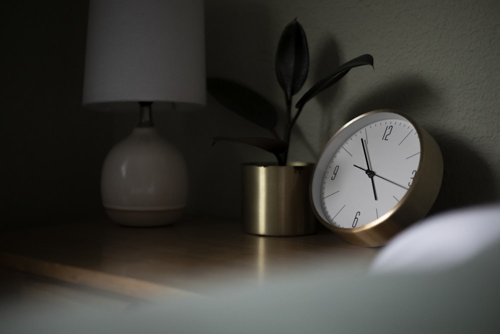 round gold-colored and white analog clock displaying 4:54 time