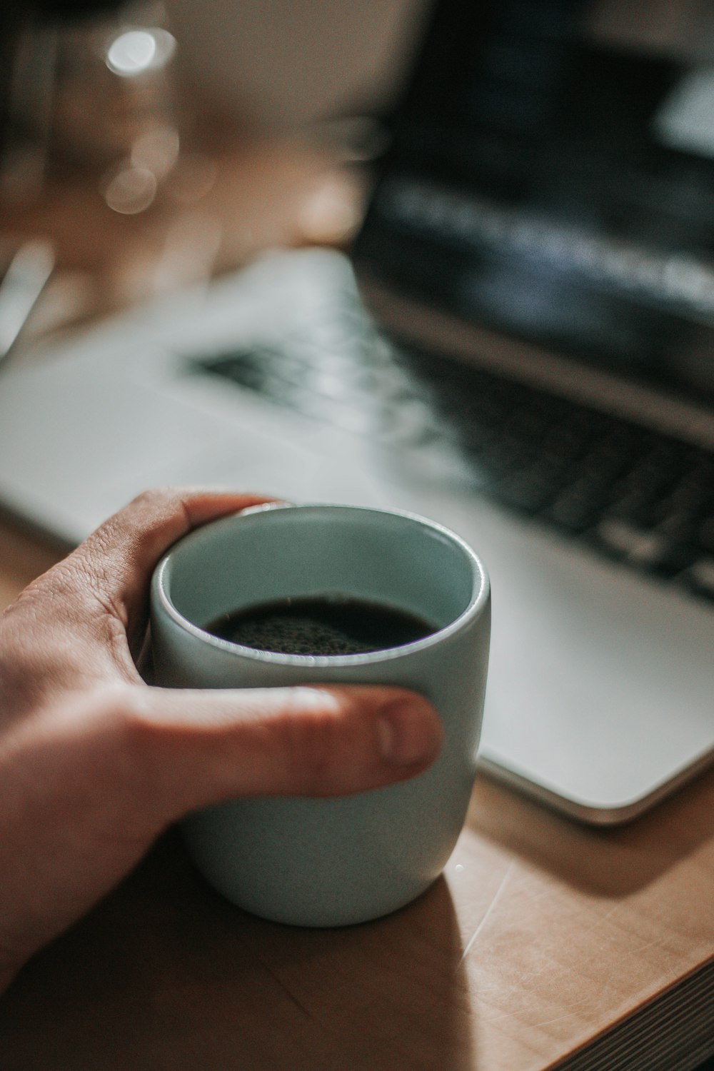 person holding blue ceramic mug