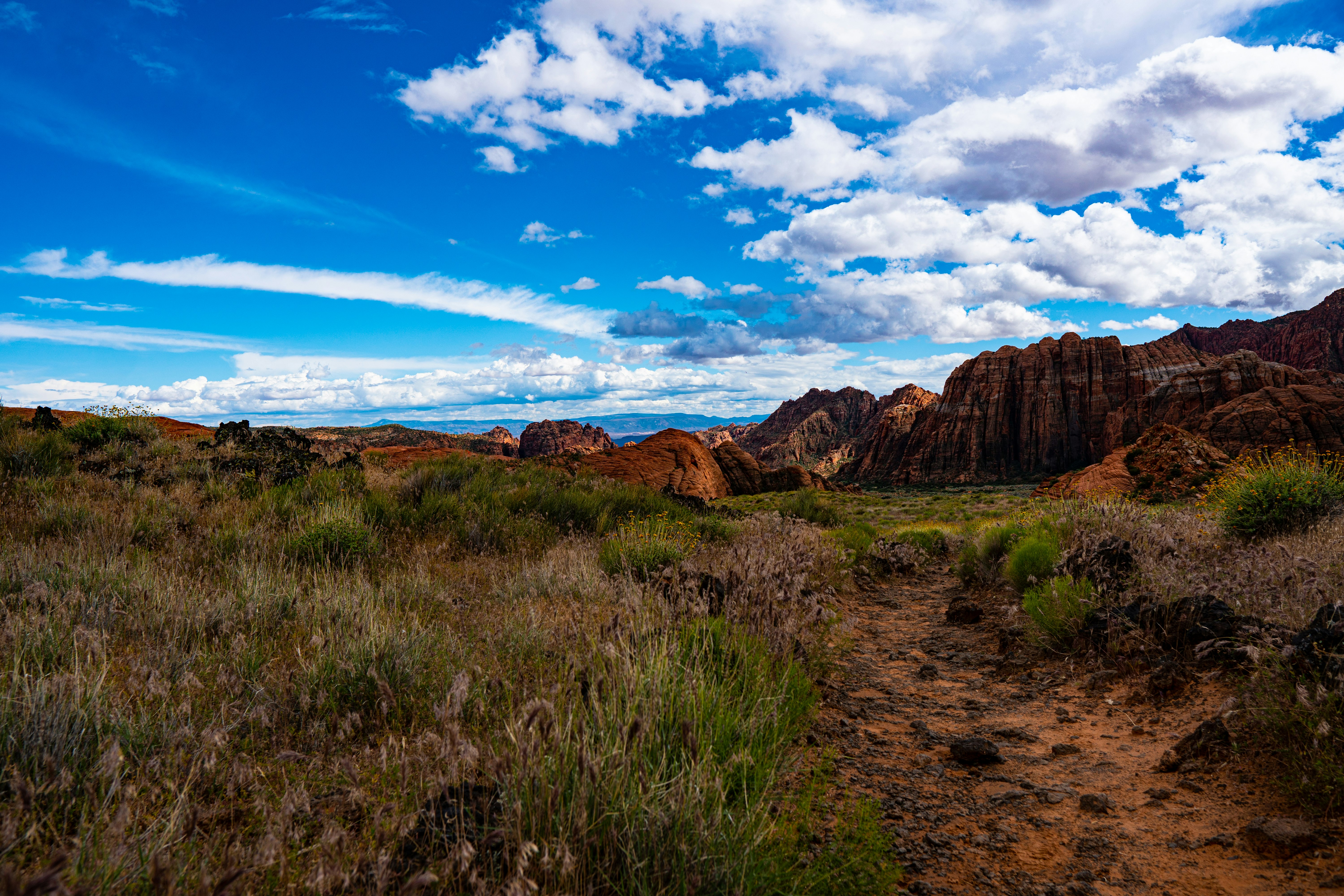 mountain range under white clouds and blue sky