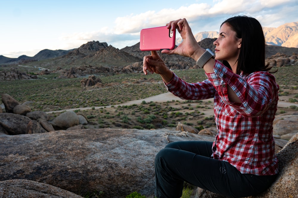 Mujer sentada sosteniendo un teléfono inteligente