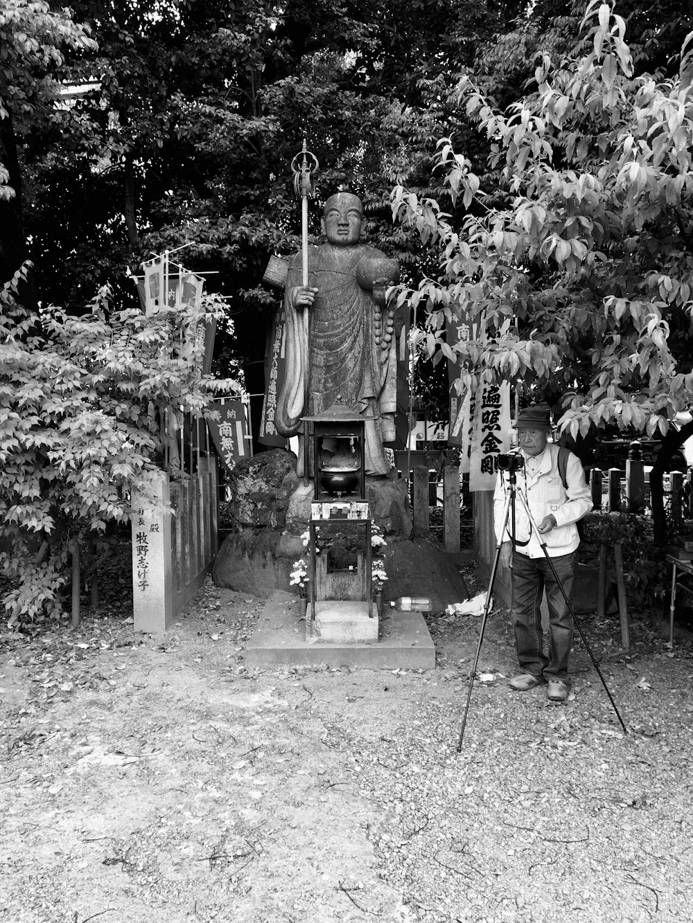 Homme debout à côté de la caméra et des arbres