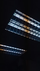 Technicians installing networked LED lighting panels in a large industrial facility.