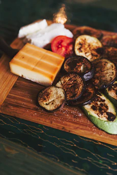 A rustic wooden cutting board with grilled meats and fresh herbs arranged invitingly.