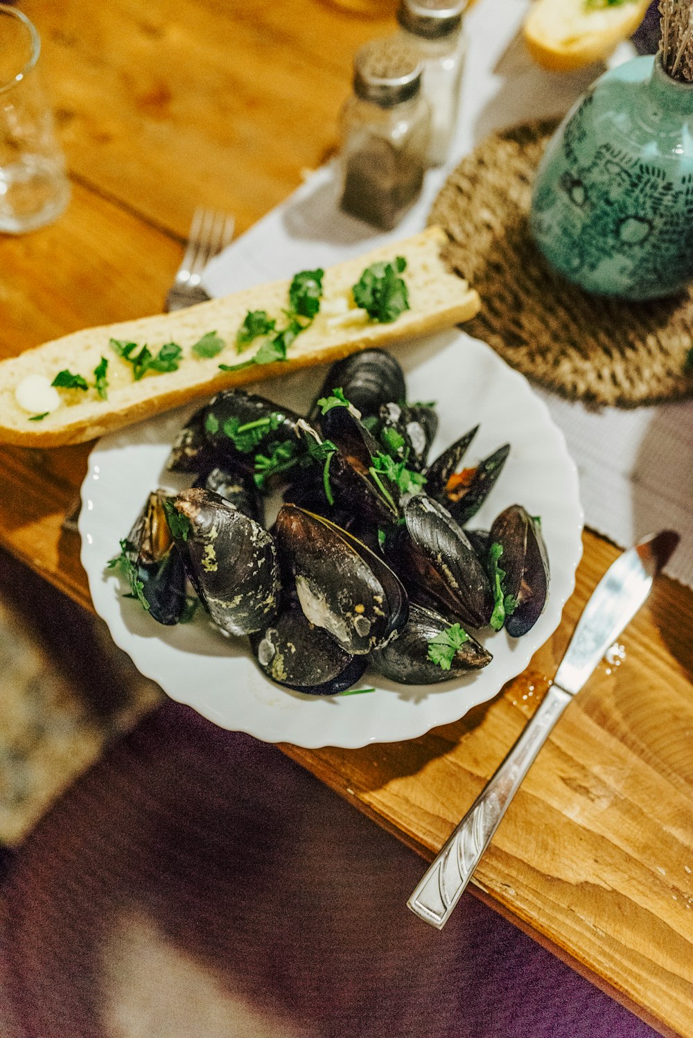 seafood delicacy in bowl near gray stainless steel knife and fork on brown wooden table