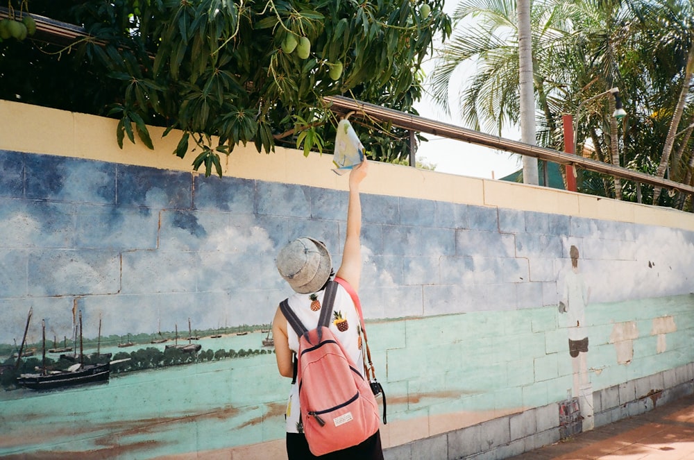 woman carrying backpack reaching light