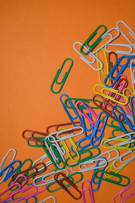 Assorted colorful hair clips and barrettes laid out on a pastel backdrop.