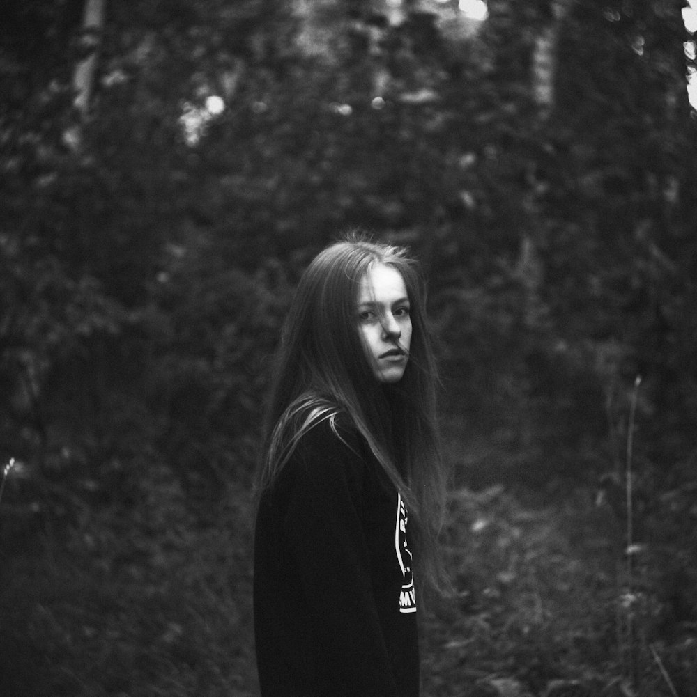 woman in black sweater standing in woods