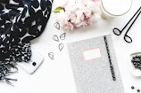 Flat lay of pink floral accessories and a notebook with handwritten links.