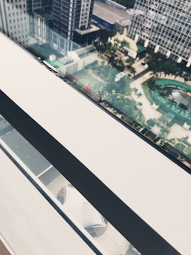 Modern cityscape viewed from a high-level office with glass reflections.