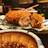 Close-up of a golden, crispy goroke on a rustic wooden plate with a side of dipping sauce.