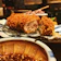 Close-up of a golden, crispy goroke on a rustic wooden plate with a side of dipping sauce.