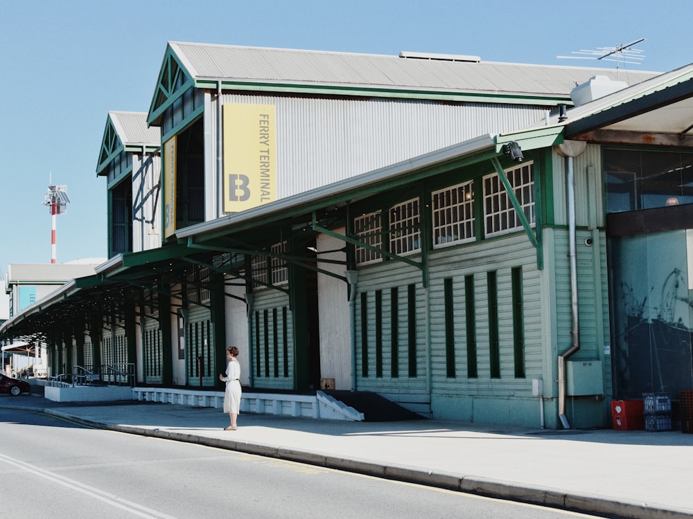 woman standing near white building