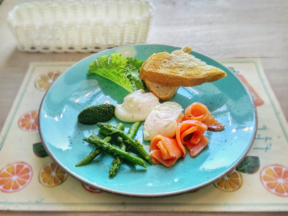 sliced bread near lettuce, asparagus, salmon, and cream on ceramic plate