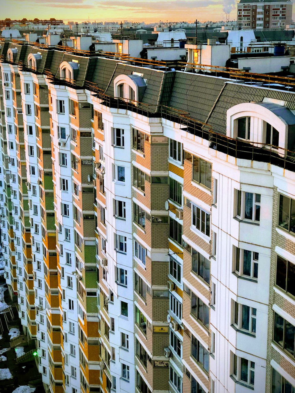 Photographie grand angle d’un immeuble de grande hauteur blanc et brun pendant la journée