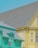 The image features two adjacent houses with distinct and vibrant colors. The house on the left is painted a bright teal color with intricate trim details and a gray shingled roof, while the house on the right is a pastel yellow with a matching roof. Both houses exhibit architectural charm, suggesting a residential neighborhood.