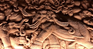 A beautifully detailed sculpture of an elephant surrounded by seven horses in motion.
