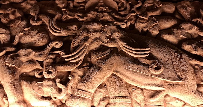 A beautifully detailed sculpture of an elephant surrounded by seven horses in motion.