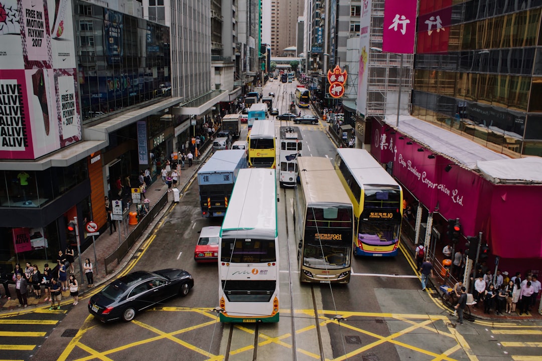 bus and other vehicles on road in between buildings