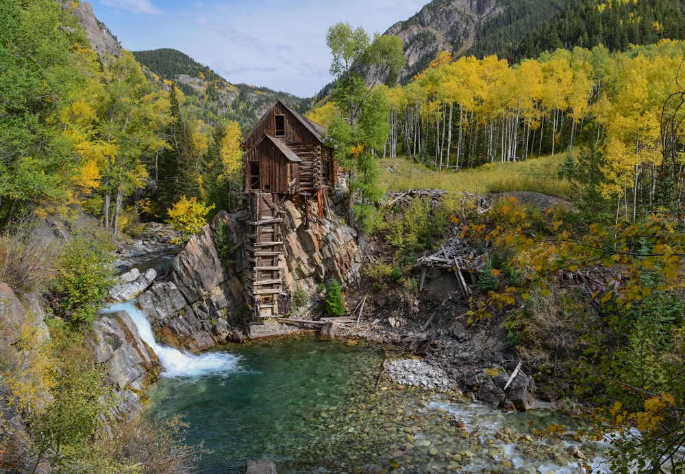 wooden house on rock formation near waterfalls