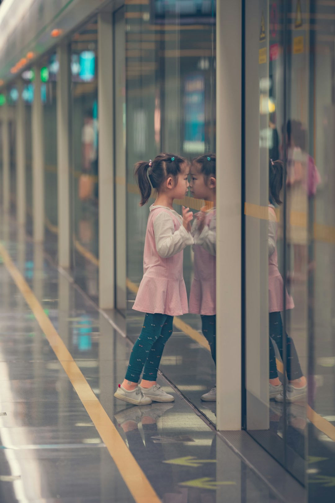 girl standing beside glass wall