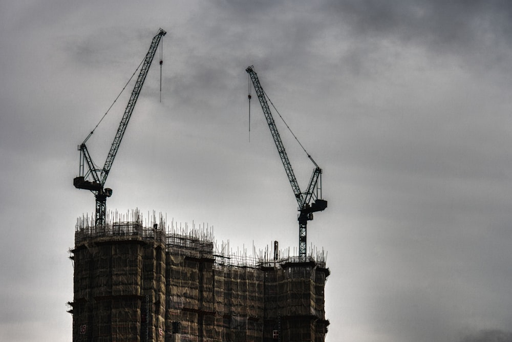 two black cranes at top of building