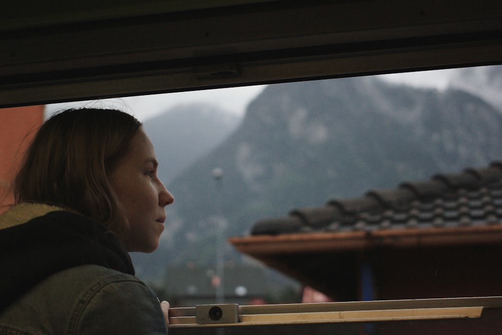 woman standing on window and looking outside