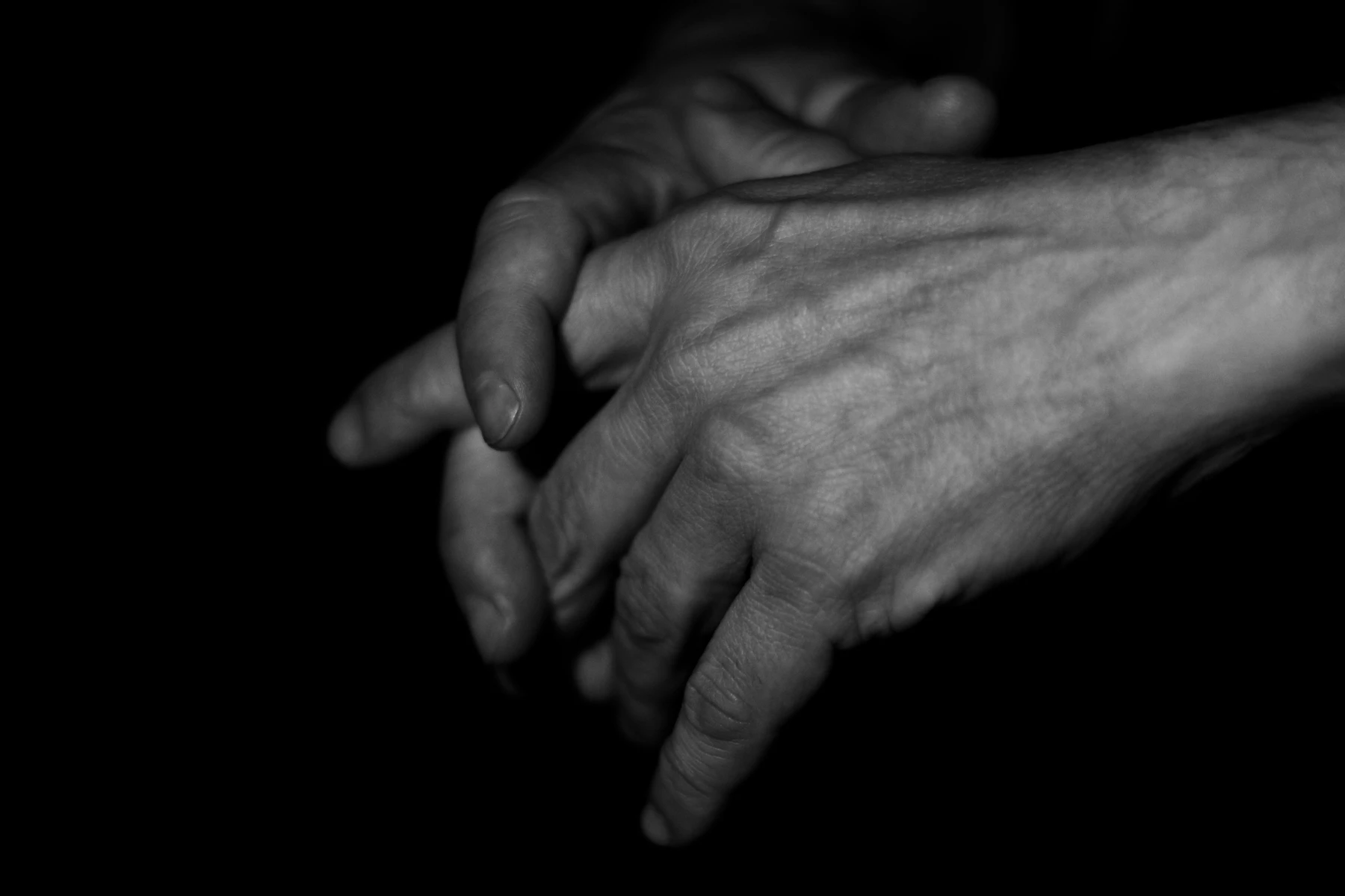 Two Hands Emerging From A Black Background