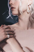Model wearing layered delicate rings with a modern street fashion outfit in soft natural light.