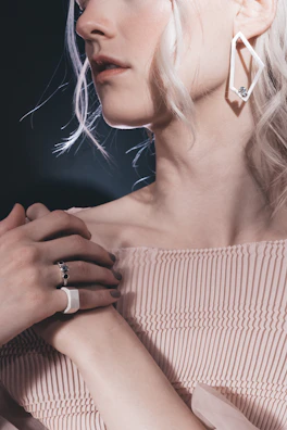 Model wearing layered delicate rings with a modern street fashion outfit in soft natural light.