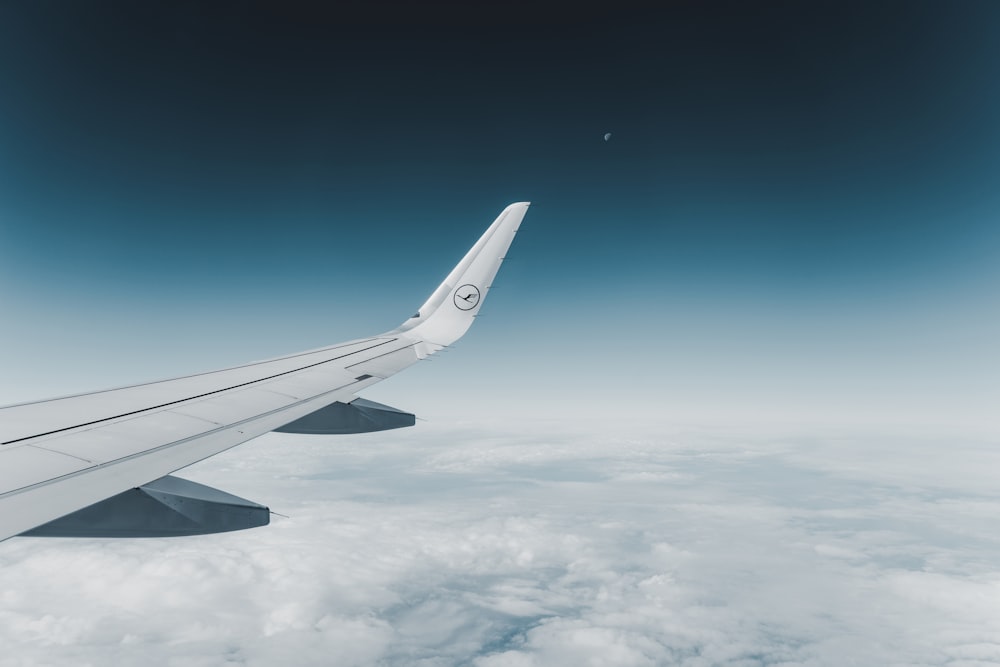 Avion blanc volant au-dessus des nuages