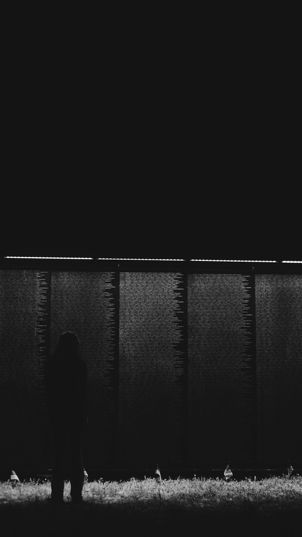 a black and white photo of a person standing in front of a wall