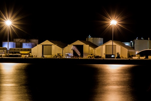 Night view of Petromag's illuminated storage tanks by the dock.