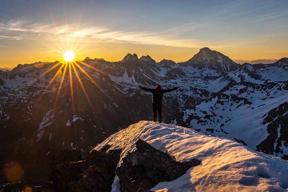 person standing on cliff during golden hour