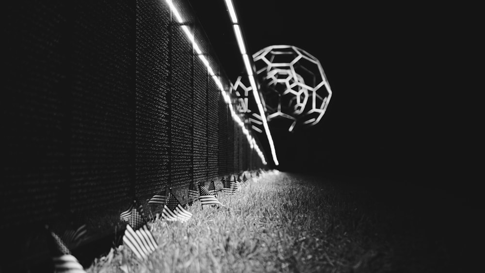 a black and white photo of a fence at night
