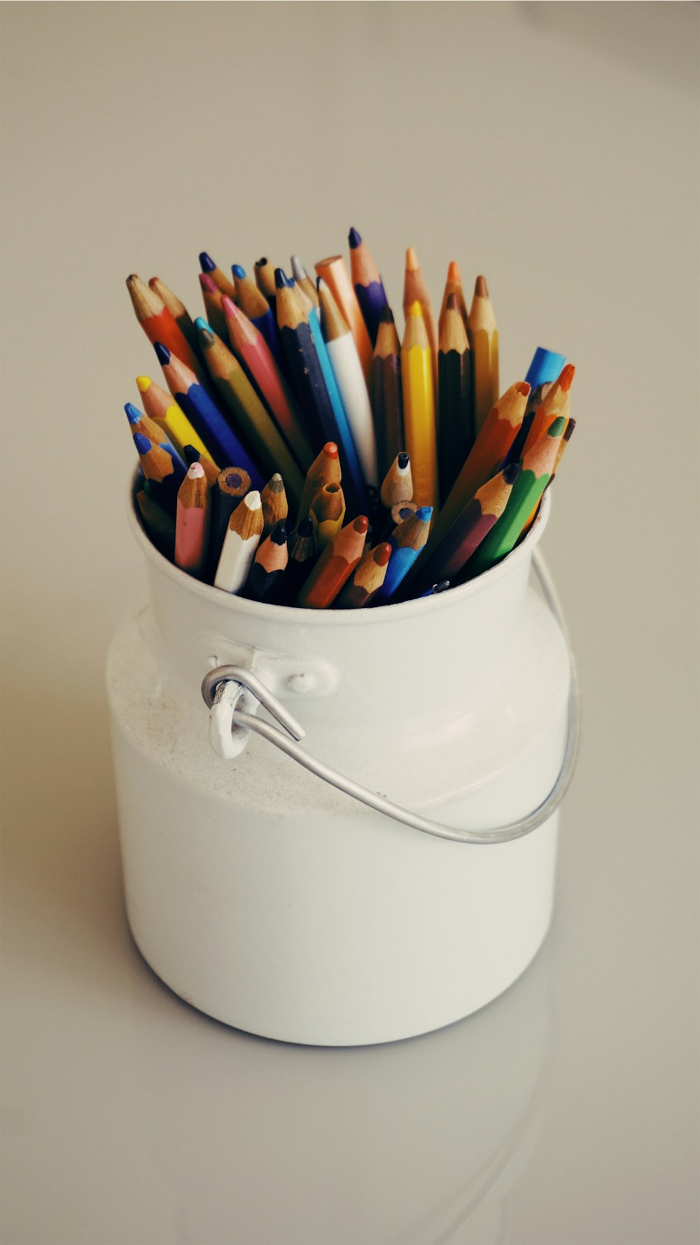흰색 양동이에 여러 가지 색상의 색칠 펜