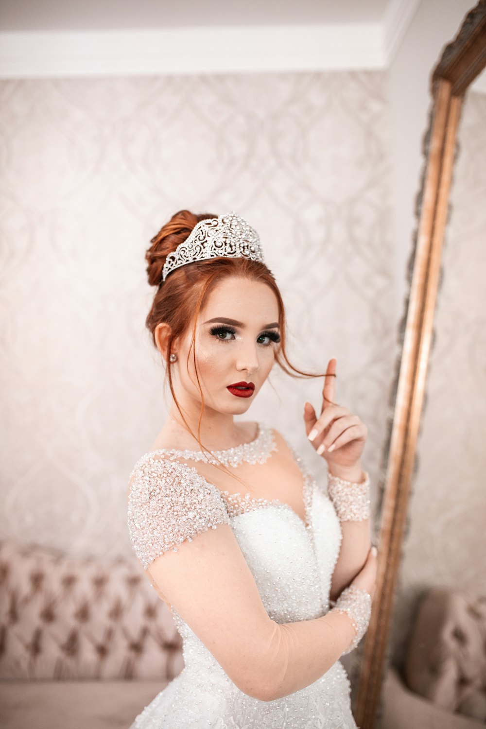 woman in white wedding gown facing the mirror