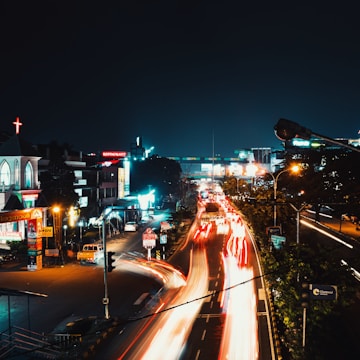 A bustling city street at night with lights.