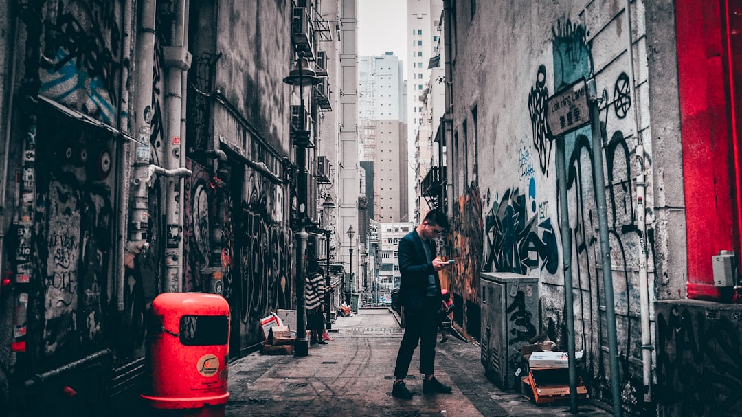 man standing between buildings