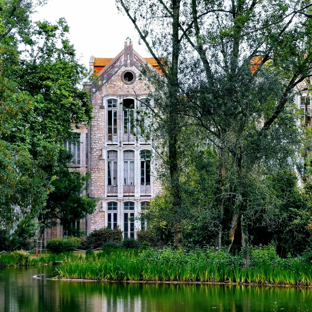 grey building near trees and pond