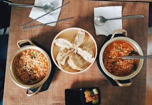 A table set for two with steaming bowls of noodles and chopsticks ready to enjoy