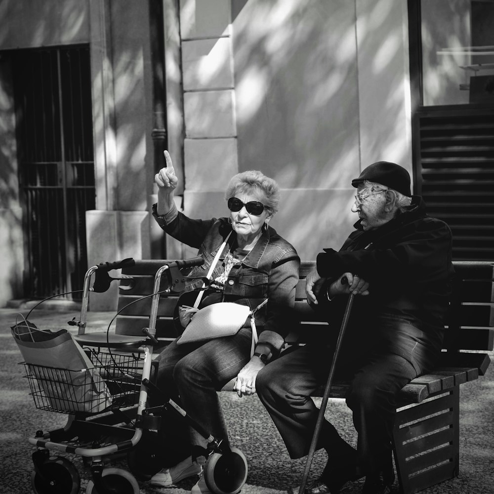 man sitting on bench beside woman