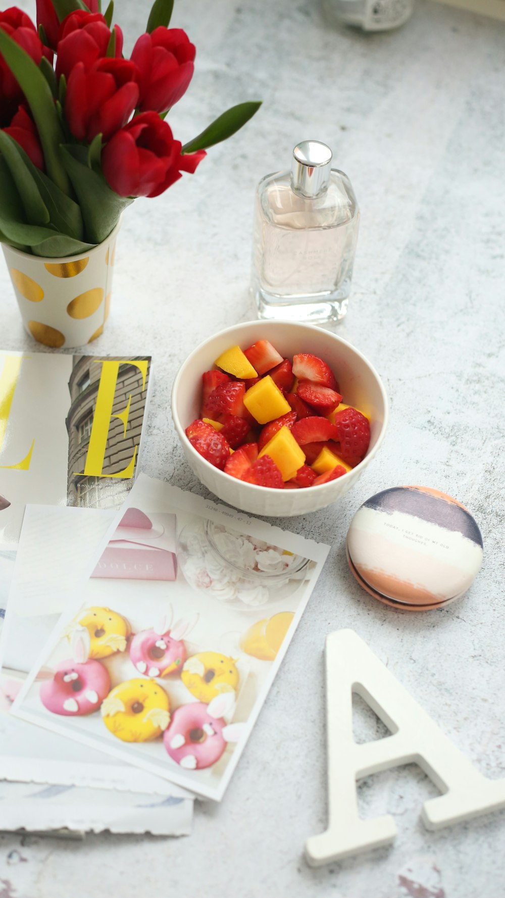 sliced strawberries on bowl beside clear glass bottle