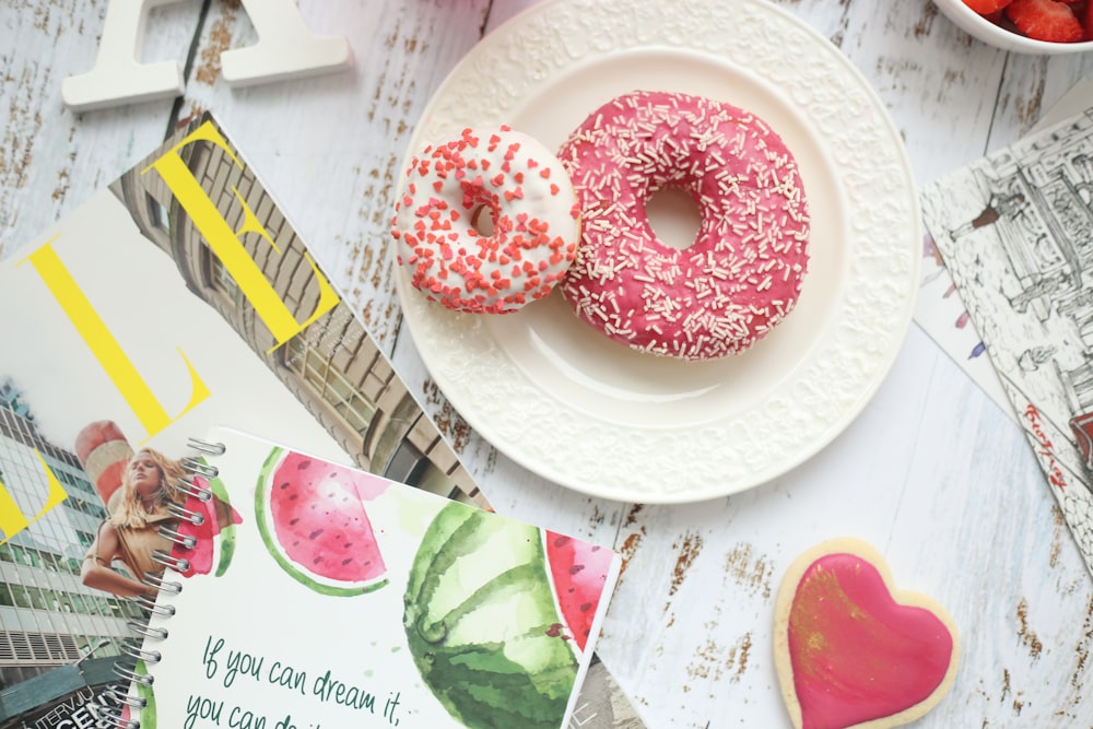 flat lay photography of two strawberry doughnuts