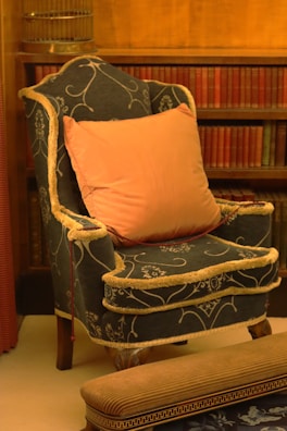 A cozy armchair upholstered in soft, patterned fabric with matching pillows.