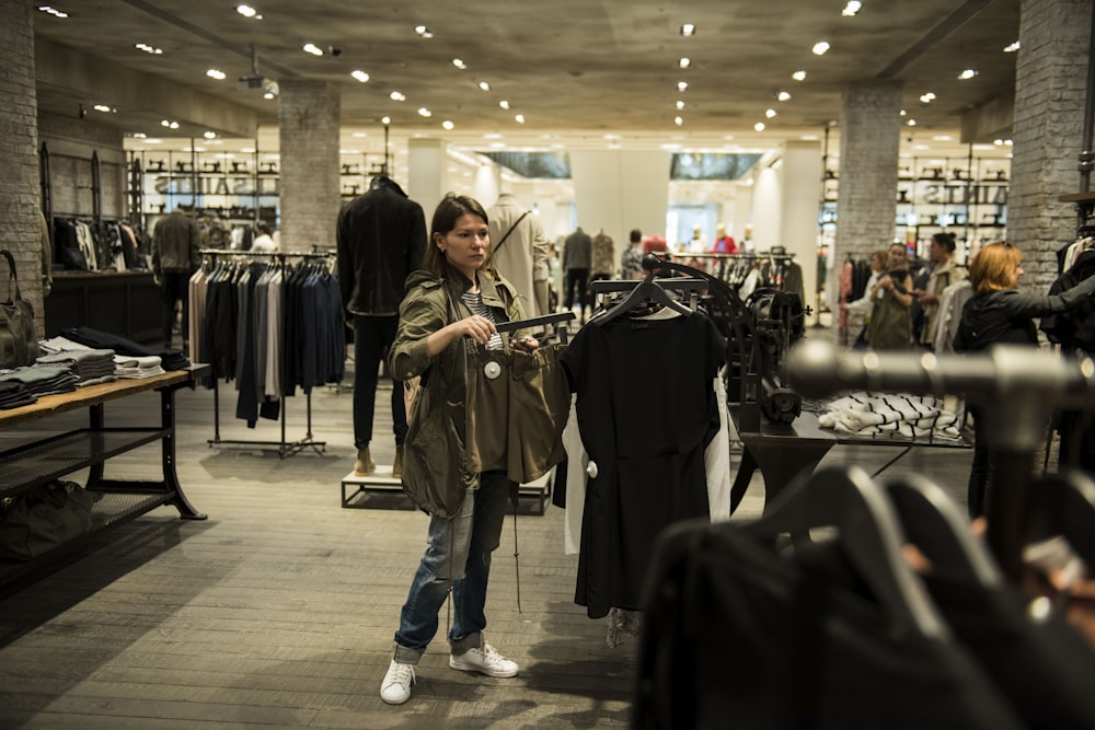 woman holding apparel inside shopping building