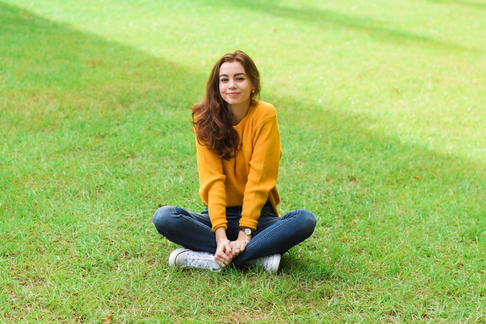 femme assise sur l’herbe verte