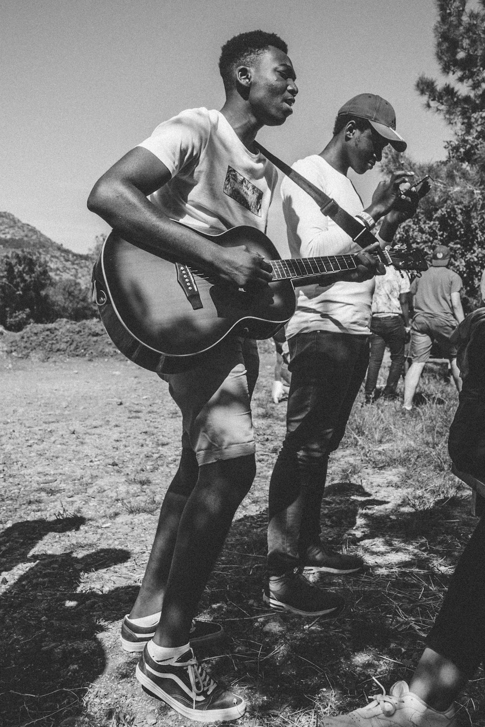 grayscale photo of two men playing instruments