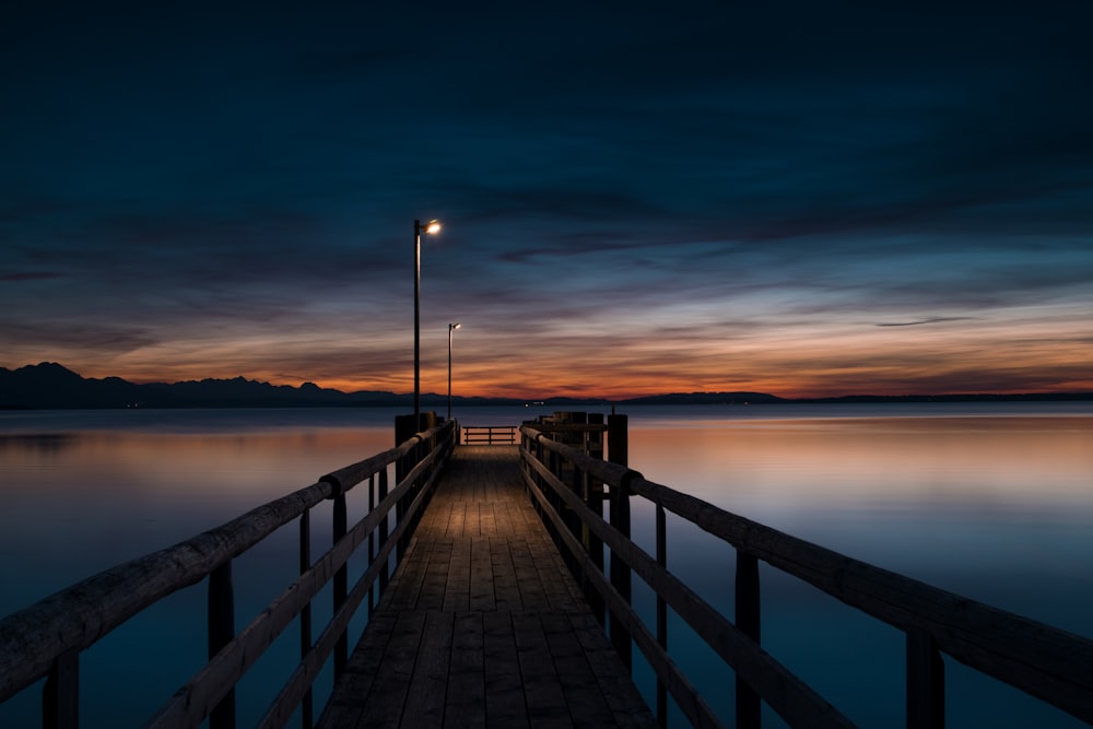 lamp post turned-on at brown wooden dock