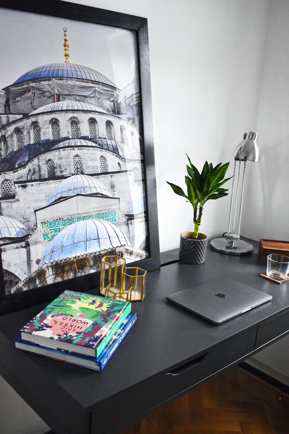 silver MacBook near blue domed church photo on table